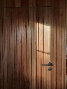 a wooden wall with a door with a metal handle at Hostería Casa Angirû in Colonia Chapadmalal +21 photos