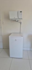a white microwave sitting on top of a refrigerator at AP Novo, Bem Localizado, Ar-Condicionado in Montes Claros +32 photos