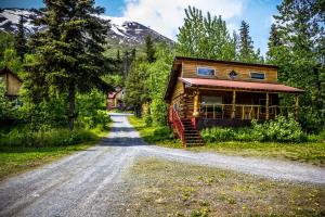 una casa al lado de un camino de tierra en Midnight Sun Log Cabins en Moose Pass