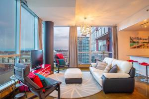 een woonkamer met een bank en een tv bij Modern Beltline Escape Sky-High Views DT Views in Calgary
