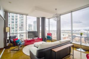 a living room with a couch and a tv at Modern Beltline Escape Sky-High Views DT Views in Calgary