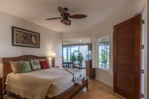 a bedroom with a bed and a ceiling fan at Mauna Lani Point stunning sunset and ocean views in Waikoloa +35 photos