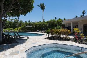 una piscina junto a una casa en 1BR Mauna Lani Point lovely mountain views, en Waikoloa