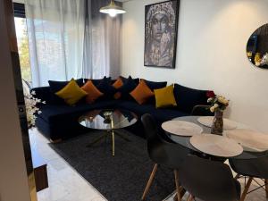 a living room with a blue couch and two tables at Studio Le Cœur Casablanca in Casablanca
