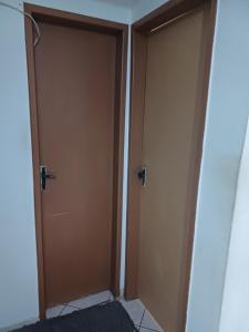 zwei Türen liegen nebeneinander in einem Raum in der Unterkunft Quarto Luz in João Pessoa