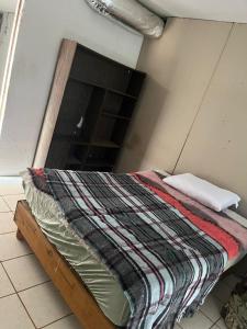 ein Bett mit einer Decke auf dem Zimmer in der Unterkunft La casa del buen paso in San Lorenzo