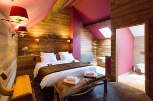 a bedroom with a large bed and a bathroom at River Lodge Hotel Insolite in Maredsous
