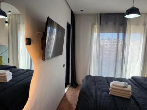 een slaapkamer met 2 bedden en een tv aan de muur bij Studio Best in Casablanca in Casablanca