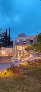 ein Gebäude mit Stühlen und Leuchten davor in der Unterkunft Hotel Alpre in Villa Carlos Paz