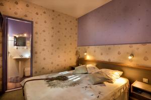 a bedroom with a bed with a mirror and a sink at Le Terminus in Villeneuve-sur-Lot