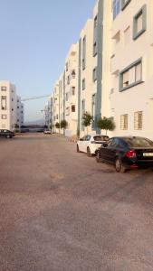 two cars parked in a parking lot next to buildings at Rayad Ajdir alhociema in Ajdir