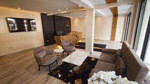 ein Wohnzimmer mit Sofa, Stühlen und einem Tisch in der Unterkunft Akira Hotel in Kigali