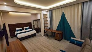 a hotel room with a bed and a desk and a couch at Akira Hotel in Kigali