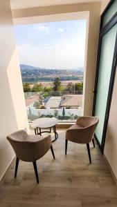 ein Zimmer mit zwei Stühlen und einem großen Fenster in der Unterkunft Akira Hotel in Kigali
