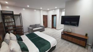 a bedroom with a large bed and a flat screen tv at Akira Hotel in Kigali +118 photos