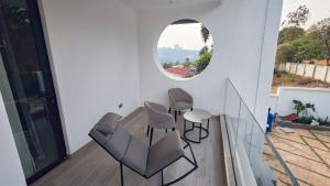 a room with two chairs and a circular window at Akira Hotel in Kigali