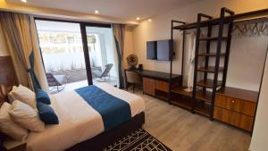 ein Schlafzimmer mit Bett, Schreibtisch und Fernseher in der Unterkunft Akira Hotel in Kigali + 119 Fotos
