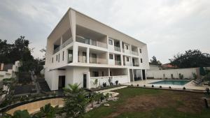 ein großes weißes Gebäude mit Schwimmbad in der Unterkunft Akira Hotel in Kigali