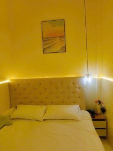a bedroom with a bed with a yellow wall at Le Cosmos Vĩnh Hy in Vĩnh Hy +32 photos