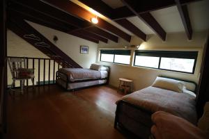 a bedroom with two beds and a stair case at Kurrajong Trails and Cottages in Colo