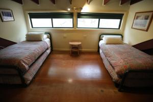 a room with two beds and a table in it at Kurrajong Trails and Cottages in Colo