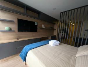 a bedroom with a bed and a flat screen tv at Loft Panorámico con estilo, Coworking-Gym, Usaquén in Bogotá