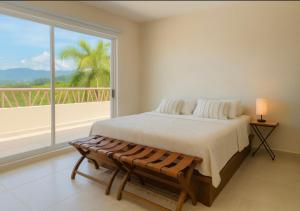 a bedroom with a bed and a large window at 2 Rec Vista a las Montañas I Amplia Terraza I Smart TV-Netflix I Wi-Fi I Recién Remodelado in Ixtapa