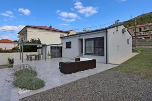 a white house with a patio in a yard at Holiday house with a swimming pool Senj - 21661 in Senj