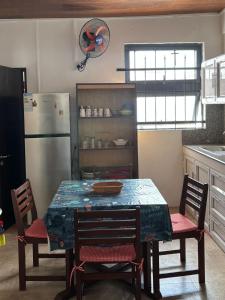 a kitchen with a table with chairs and a refrigerator at Corinne Villa à 300m from the beach in Grand Baie