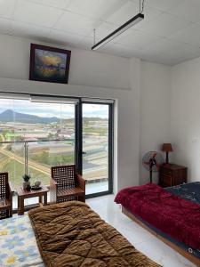 a bedroom with a bed and a large window at ONEA coffee Homestay in Trai Mat