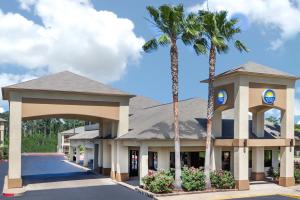 un hotel con palme e un edificio di Days Inn & Suites by Wyndham Huntsville a Huntsville