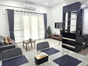 a living room with a couch and a table at Hatyai Luxe Stay in Hat Yai