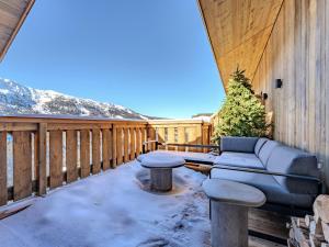 eine Terrasse mit einem Sofa und einem Tisch auf einer Terrasse in der Unterkunft Penthouse alpin moderne à Méribel, 12 pers., cheminée, service hôtelier 5* - FR-1-613-136 in Les Allues