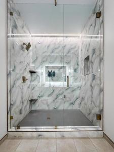 a white marble shower with a glass wall at Harbor Suites at Harborwalk Village in Destin +86 photos