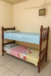 ein Etagenbett aus Holz in einem Zimmer mit einer Matratze in der Unterkunft Casa de Hospedagem Ave Maria 2 in Cachoeira Paulista
