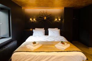 a bedroom with a large bed with towels on it at River Lodge Hotel Insolite in Maredsous