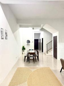 a dining room with a table and a rug on the floor at Salak Lestari Homestay Klia Klia2 in Sepang