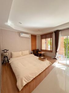 ein Schlafzimmer mit einem großen weißen Bett in einem Zimmer in der Unterkunft Maduel Resort Kohlarn in Ko Larn