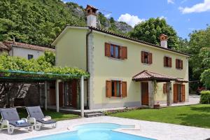 a house with a swimming pool in front of it at Family friendly house with a swimming pool Dolenja Vas, Central Istria - Sredisnja Istra - 24521 in Dolenja Vas