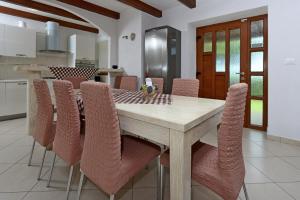 a dining room with a wooden table and chairs at Family friendly house with a swimming pool Dolenja Vas, Central Istria - Sredisnja Istra - 24521 in Dolenja Vas