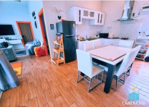 a kitchen with a table and chairs and a refrigerator at The time's pool villa in Ban Bung