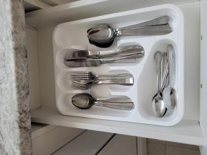 a drawer filled with silver utensils in a cabinet at Spacious and comfortable accommodation in Longueuil