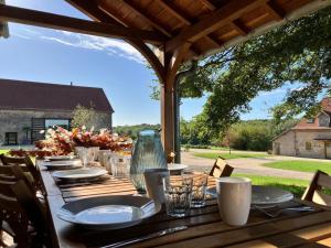 La FayeにあるGîte paisible pour 14 pers. avec Wi-Fi et animaux admis en Allier - FR-1-489-593の長い木製テーブル(皿、皿付)