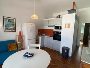 a kitchen with a white table and a white refrigerator at Appartement F3 à la Marina Pointe-du-Bout, Martinique - FR-1-765-33 in Lazaret