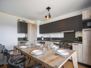 a kitchen with a wooden table with plates and wine glasses at Appartement T3 cabine à Nantailly, 8 personnes, garage - FR-1-809-23 in Les Saisies