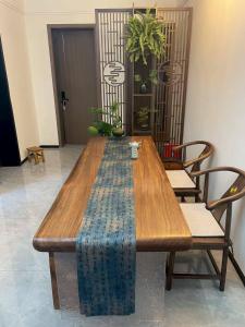 a wooden table in a room with chairs at Qingwu Lane in Luoyang