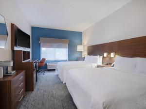 a hotel room with two beds and a television at Holiday Inn Express & Suites Augusta West - Ft Gordon Area by IHG in Augusta