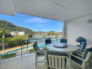 a dining room with a table and chairs and a balcony at Beachside 17 in Nelly Bay