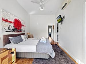 a bedroom with a bed and a tv on a wall at Beachside 17 in Nelly Bay