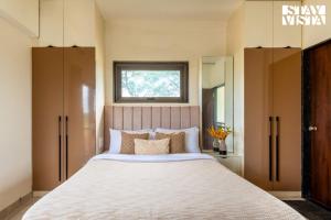 a bedroom with a large bed with a window at Mizu Retreat by VEO - Part of StayVista in Karjat
